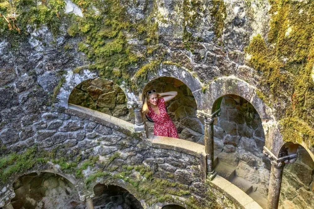 Chica dentro del Pozo Iniciatico en la Quinta da Regaleira en Sintra, Portugal